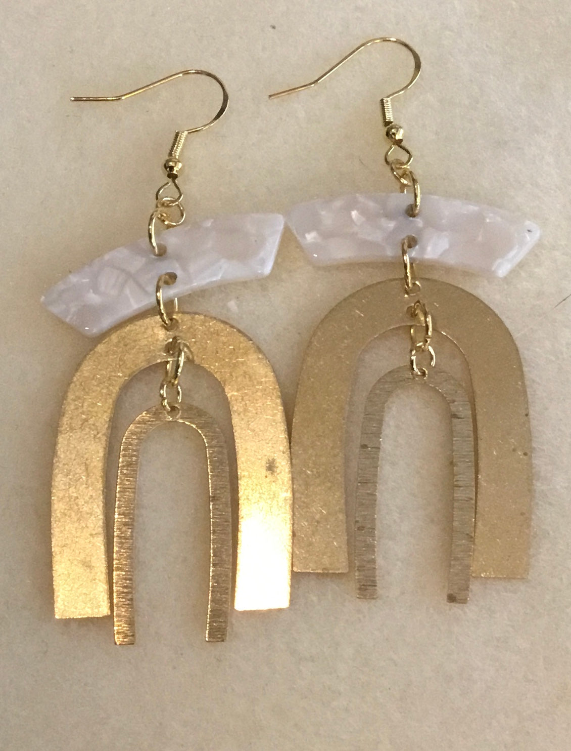 White irregular pendant with brass rainbows